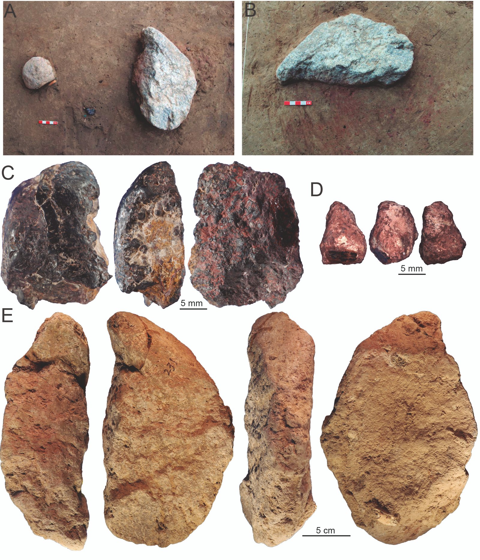 Pièces d'ocre et équipement de traitement de la pierre posés sur une tache de pigment teintée de rouge.