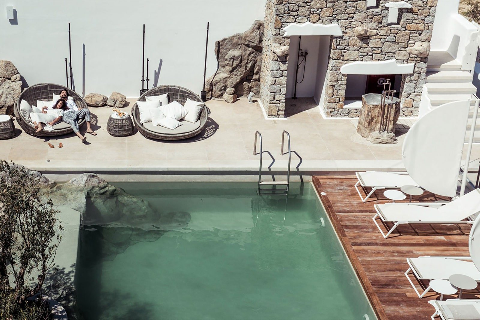 L'image peut contenir des meubles d'eau de piscine chaise bâtiment personne humaine piscine hôtel logement villa et maison