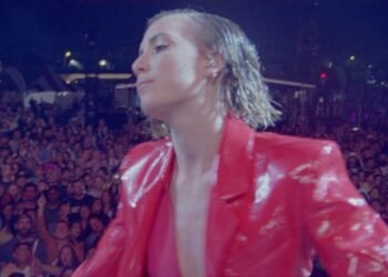 L'image peut contenir des vêtements une personne humaine et un manteau