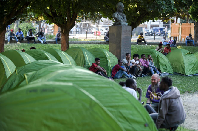 Des migrants sont assis près de leurs tentes sur la place Daviais dans le centre de Nantes dans le cadre d'une action symbolique le 3 juillet 2019.