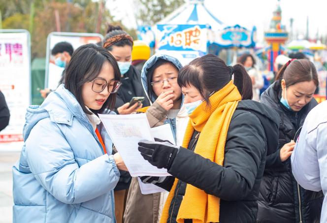 Des demandeurs d'emploi recherchent des informations lors d'un salon de l'emploi à Nantong, dans la province chinoise du Jiangsu, le 8 février 2022.