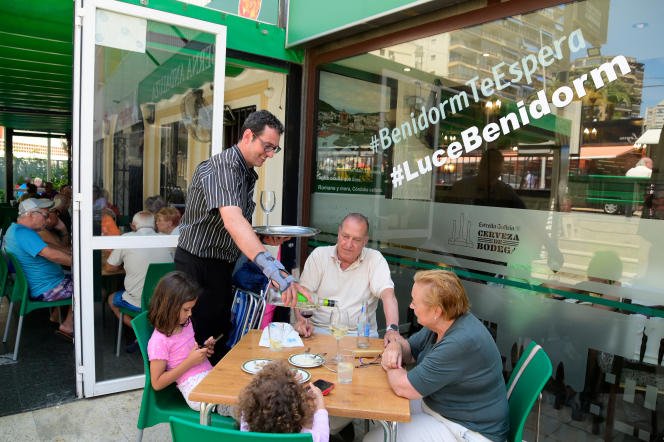 Le propriétaire du restaurant 'Taberna Andaluza', Pablo Gonzalez, sert des clients, sur la plage de Levante à Benidorm, le 7 juin 2022.