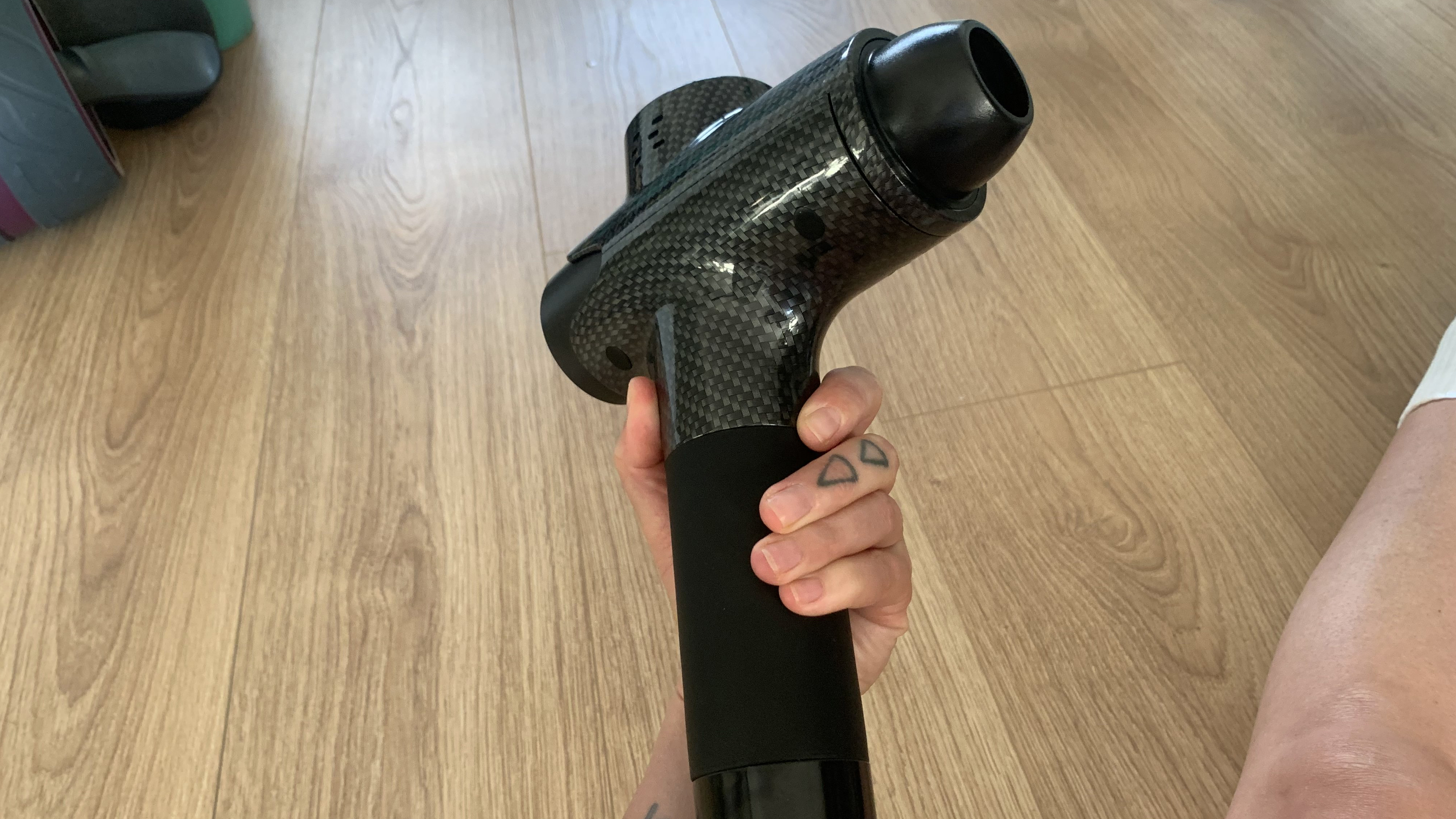 Pistolet de massage Lairlux tenu dans la main du testeur