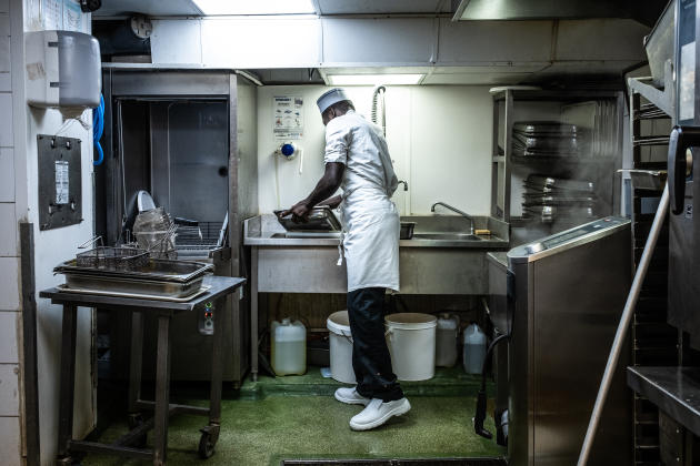 Dieuvenor, 30 ans, plongeur, est arrivé d'Haïti en 2017. Sa procédure de régularisation est en cours d'examen.  Ici, dans la cuisine du Café du Commerce, à Paris, en juin 2022.