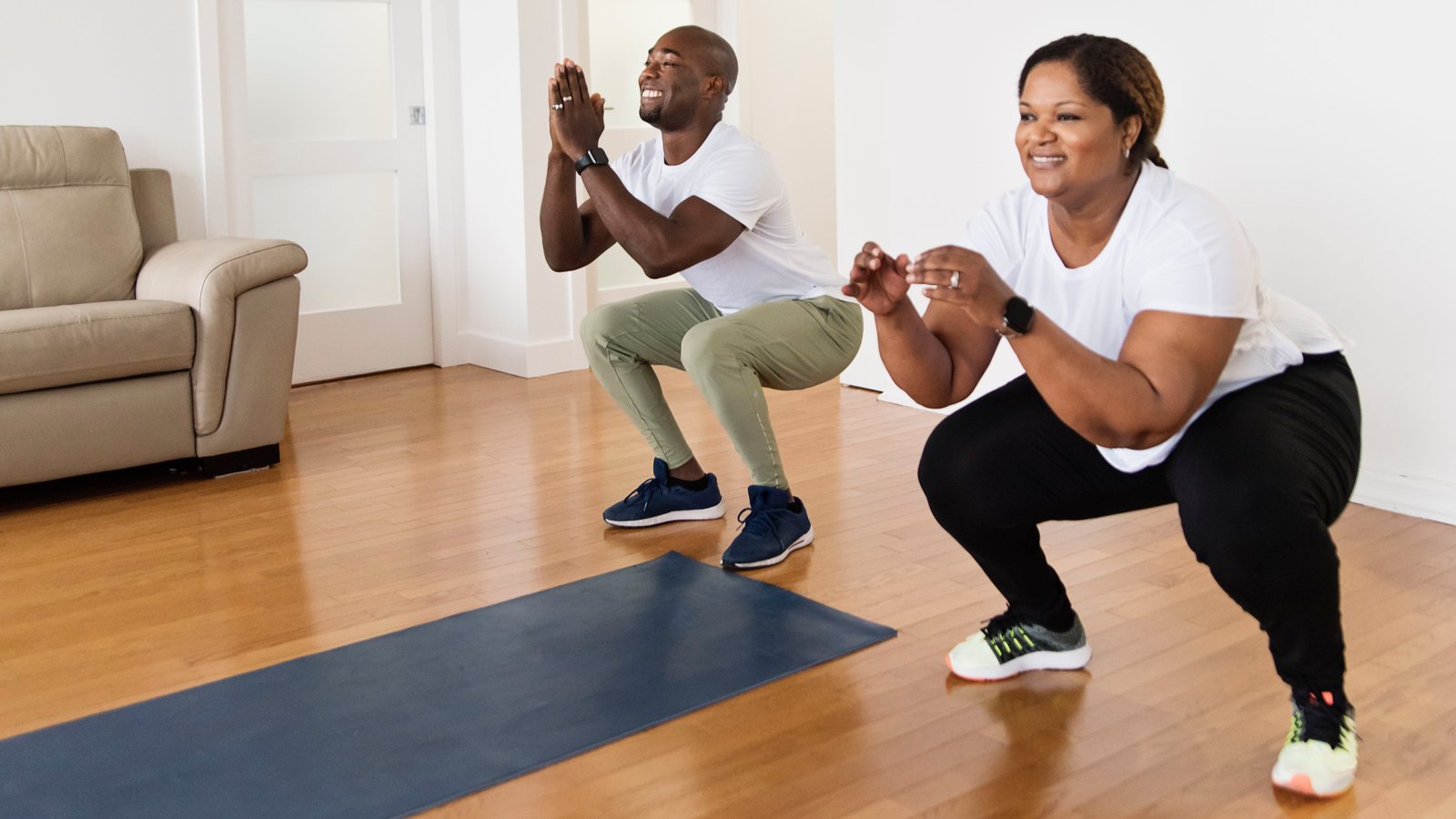 Couple effectuant des squats de poids corporel pour activer les muscles fessiers