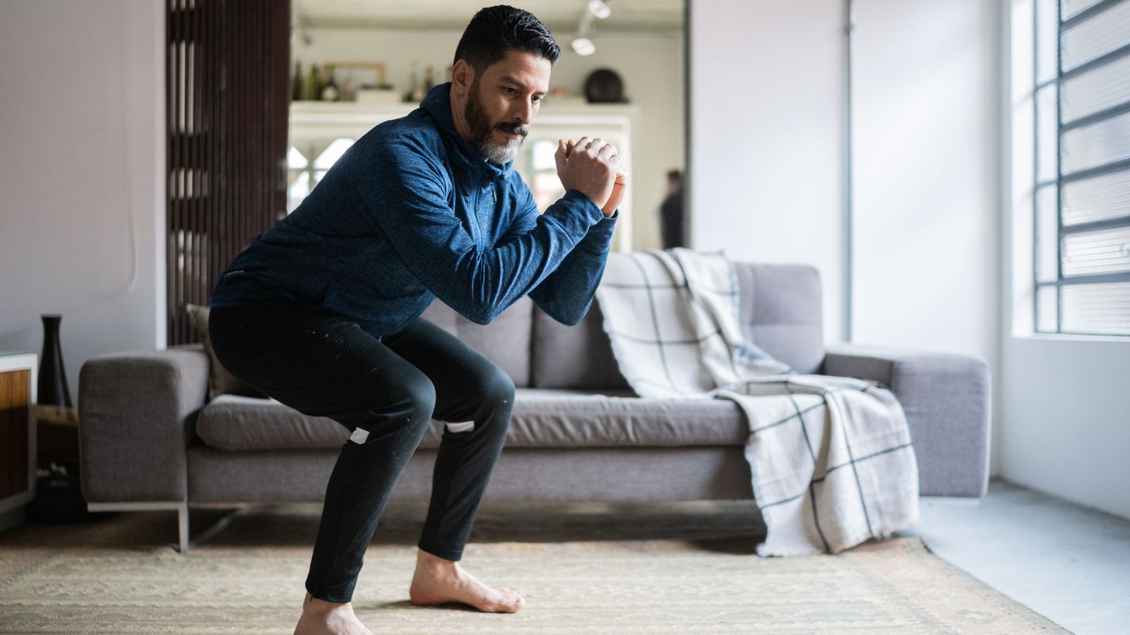 Homme faisant des squats à la maison