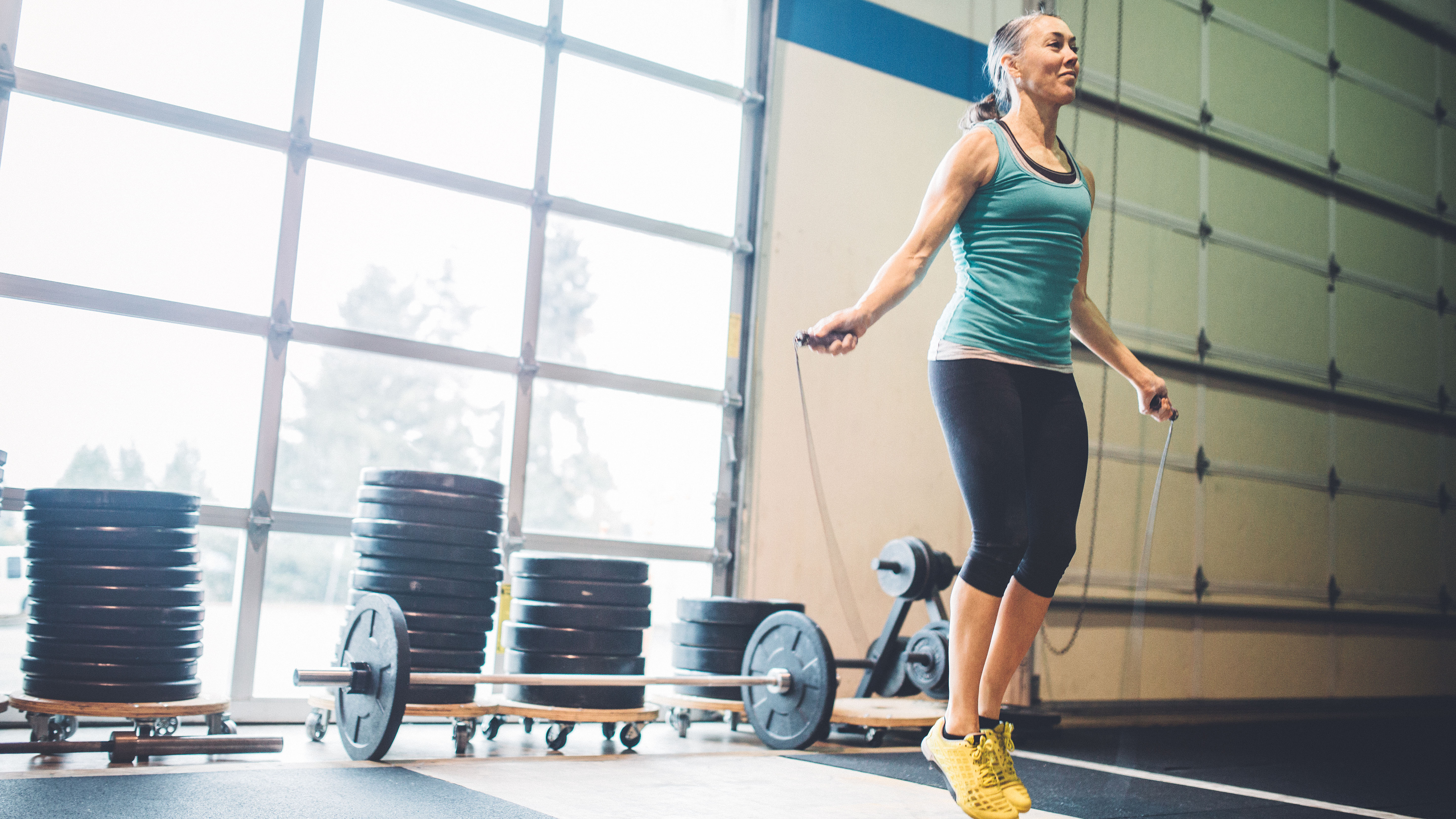 Femme mûre, sauter à la corde dans la salle de sport