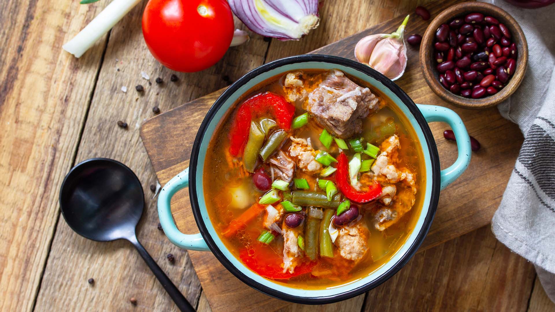 Soupe épaisse anglaise traditionnelle avec du boeuf, des haricots et des légumes sur une table en bois.