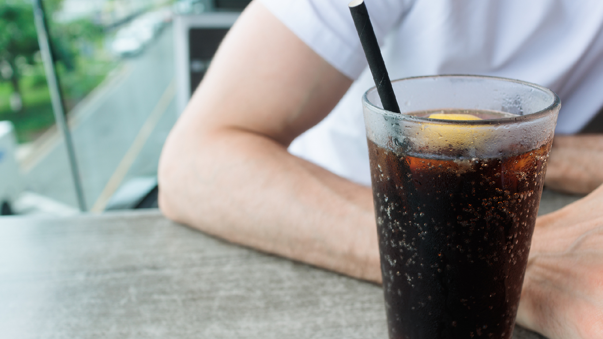 homme assis à côté d'un verre de soda light