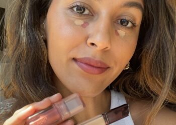 Une femme tenant un nettoyant et un blush liquide avec un débardeur blanc dessus