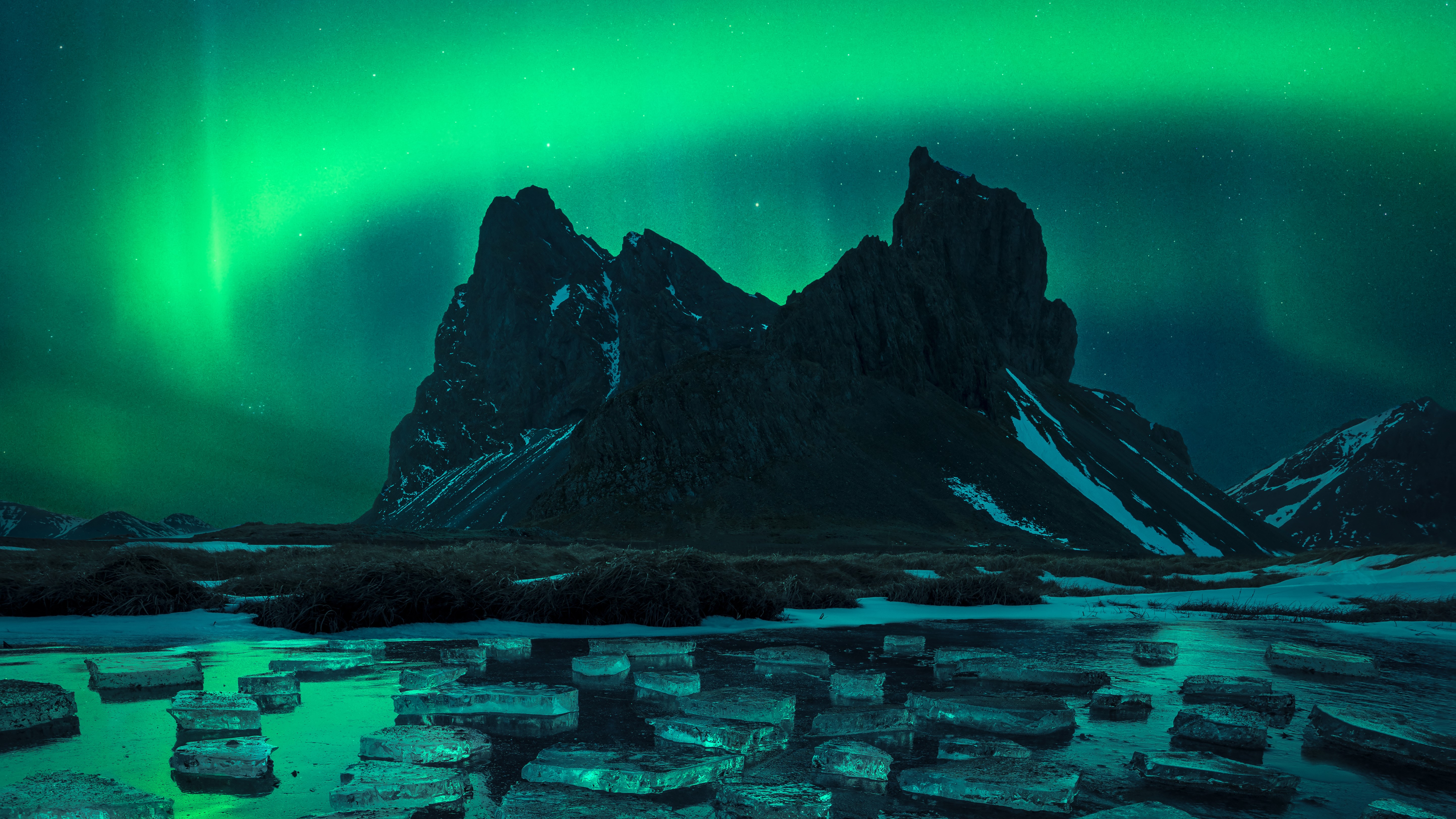 L'aurore brille en vert au-dessus d'un lac recouvert de glace dans la photographie gagnante dans la catégorie Aurorae.