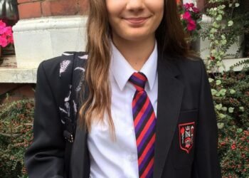 L'image peut contenir une cravate, un accessoire, un accessoire, une personne humaine, un costume, un manteau, des vêtements, un pardessus, un vêtement et un adolescent blond.