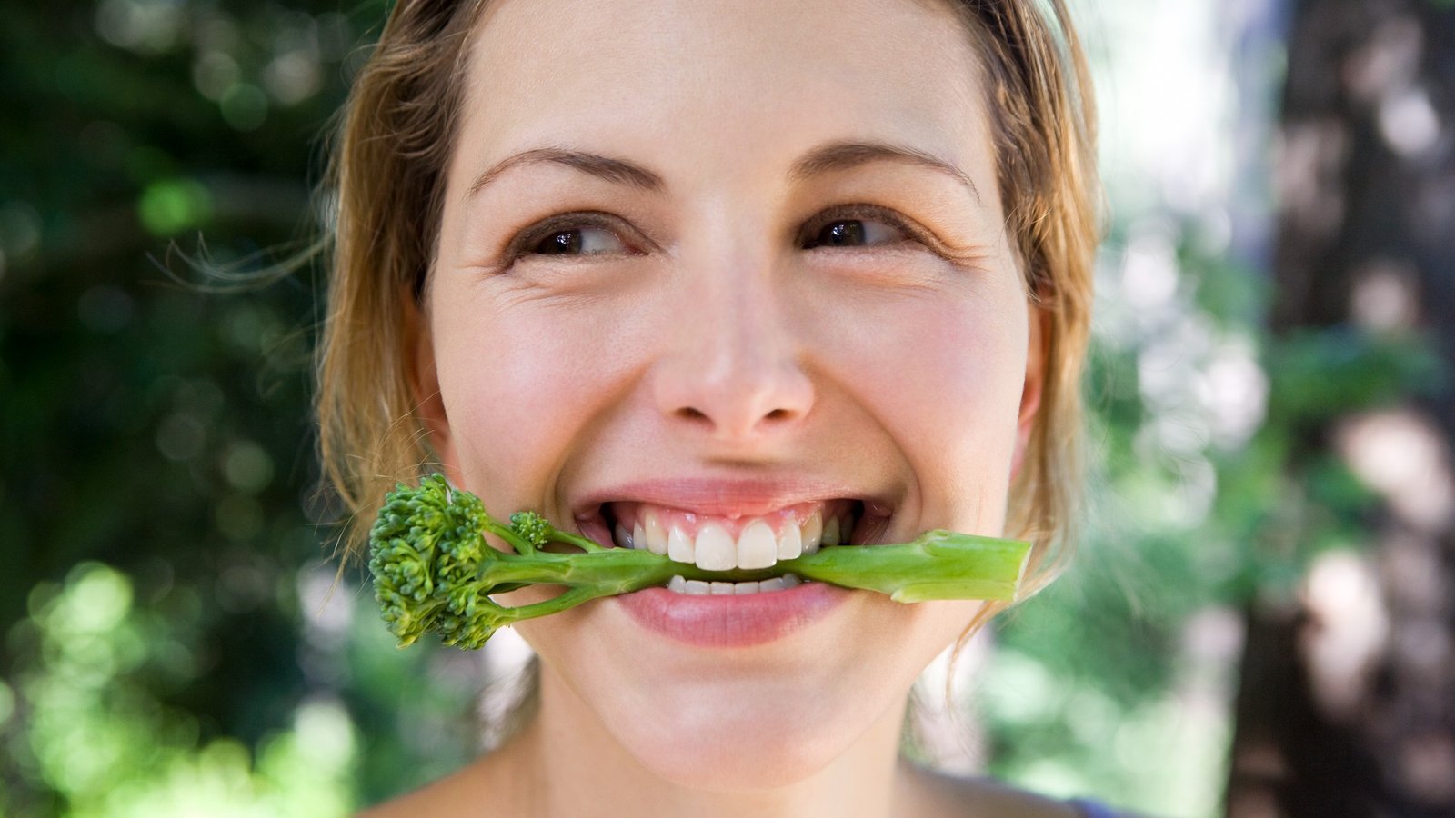 Femme mordant dans le brocoli