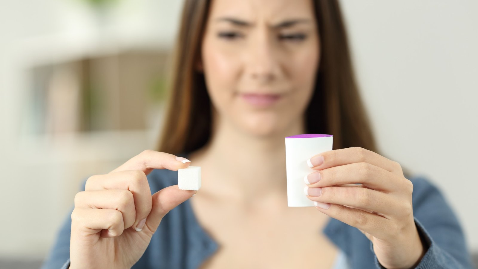 Femme débattant entre le sucre et l'édulcorant artificiel