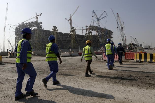 Des ouvriers marchent vers le stade Lusail, le plus grand des huit stades devant accueillir les matches de la Coupe du monde 2022, construit dans la ville du même nom au nord de Doha, le 20 décembre 2019.
