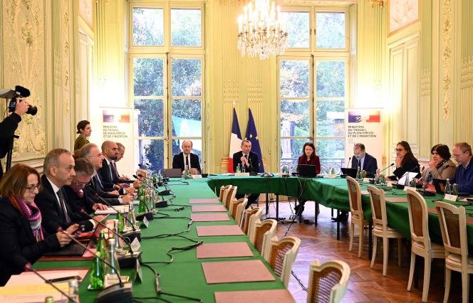 Le ministre du Travail, Olivier Dussopt (au centre), lors d'une réunion avec les syndicats sur la nouvelle réforme de l'assurance chômage, au ministère du Travail, à Paris, le 21 novembre 2022.  