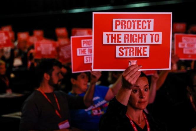 Des membres du public tiennent des pancartes indiquant « Protégez le droit de grève », au cours de la troisième journée du Congrès des syndicats (TUC), le 20 octobre 2022, à Brighton, au Royaume-Uni. 