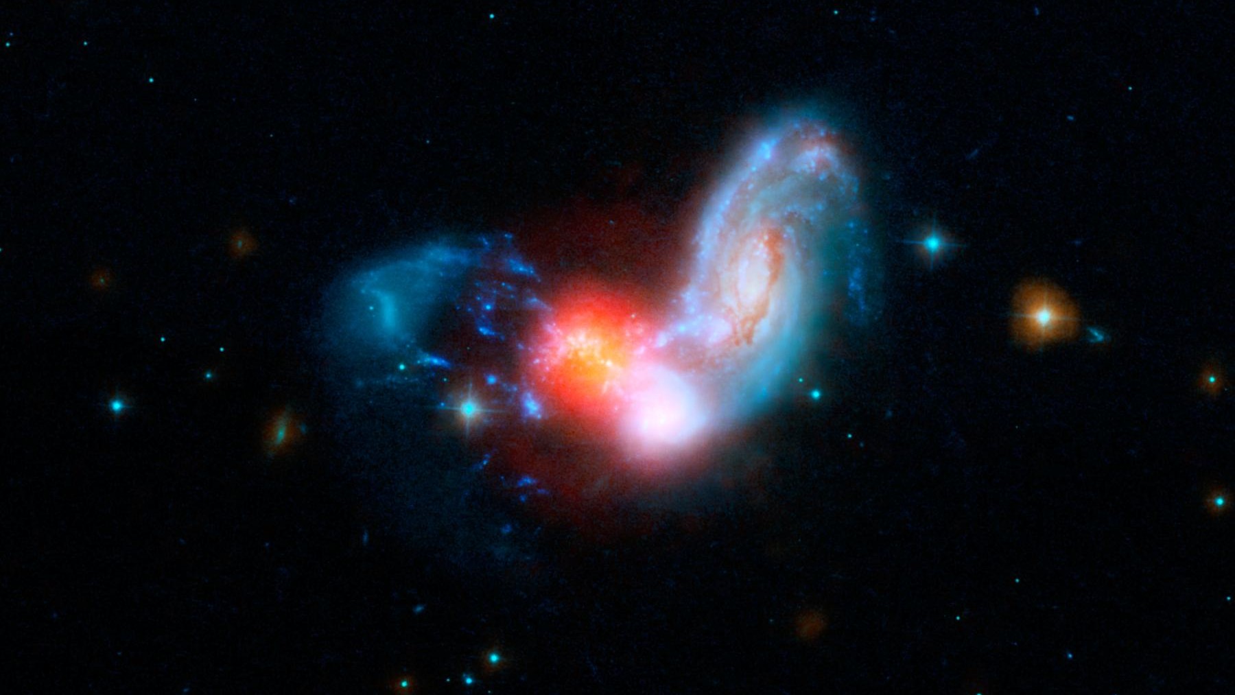 Deux galaxies spirales entrent en collision, déclenchant une explosion de formation d'étoiles (rouge). Les astronomes soupçonnent que la Voie lactée a atteint sa taille moderne grâce à une série de fusions comme celle-ci.