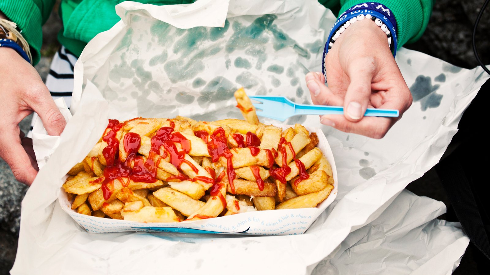 femme mangeant des frites dans un récipient