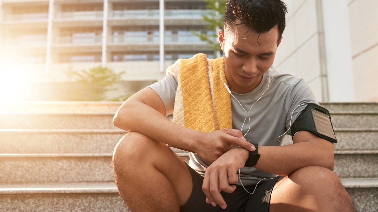 Comment fonctionnent les compteurs de pas ?  l'image montre un coureur sur des marches regardant un tracker de fitness