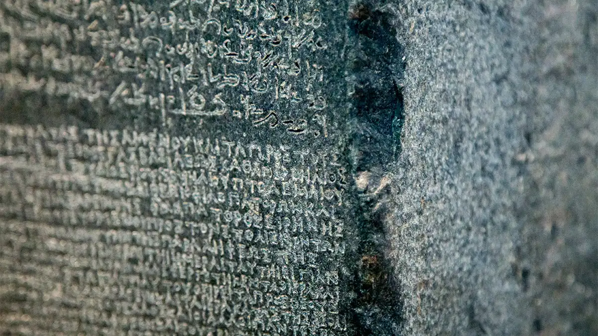 Un gros plan de la pierre de Rosette montrant deux des trois langues différentes dessus.