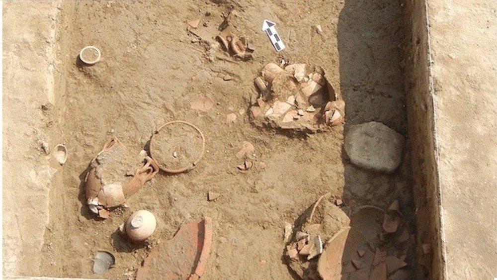 Une vue à vol d'oiseau du site d'excavation avec des tessons de poterie.