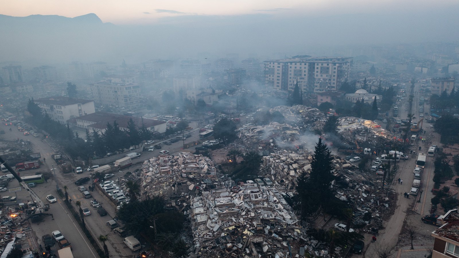 De la fumée s'échappe de bâtiments effondrés à Hatay, en Turquie.