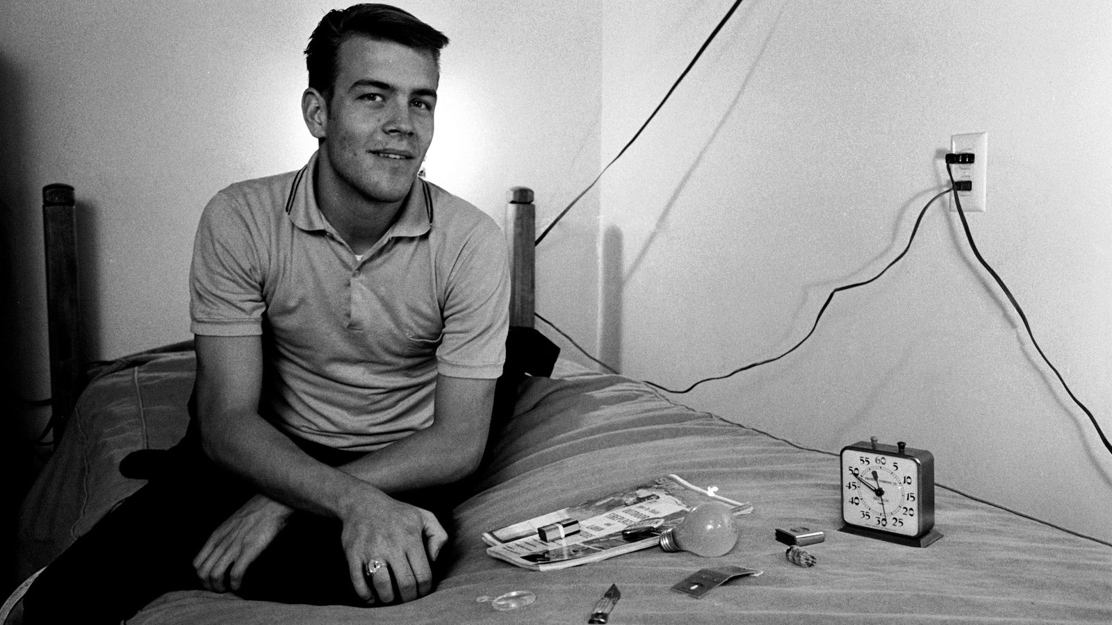 L'étudiant américain Randy Gardner est assis sur un lit à côté de divers objets ménagers qu'il devra plus tard identifier par mémoire dans le cadre d'une expérience de privation de sommeil, San Diego, Californie, 1964.