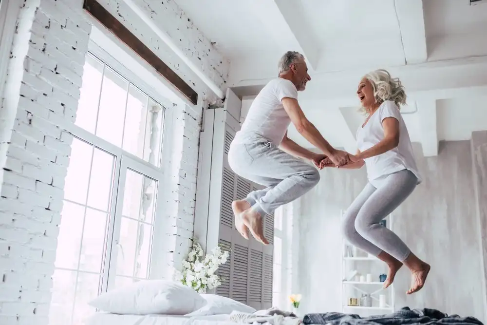 Vieux couple sautant sur le lit, confort, photographie au flash, geste