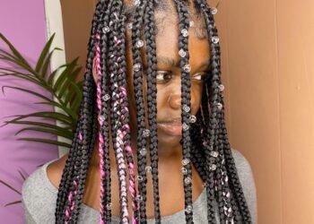 Image d'une femme noire portant des tresses de pluie.