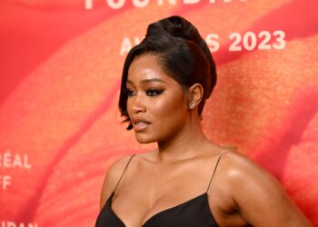 Keke Palmer apparaît sur le tapis rouge dans une robe noire.  Elle porte ses cheveux dans une touche française chic.