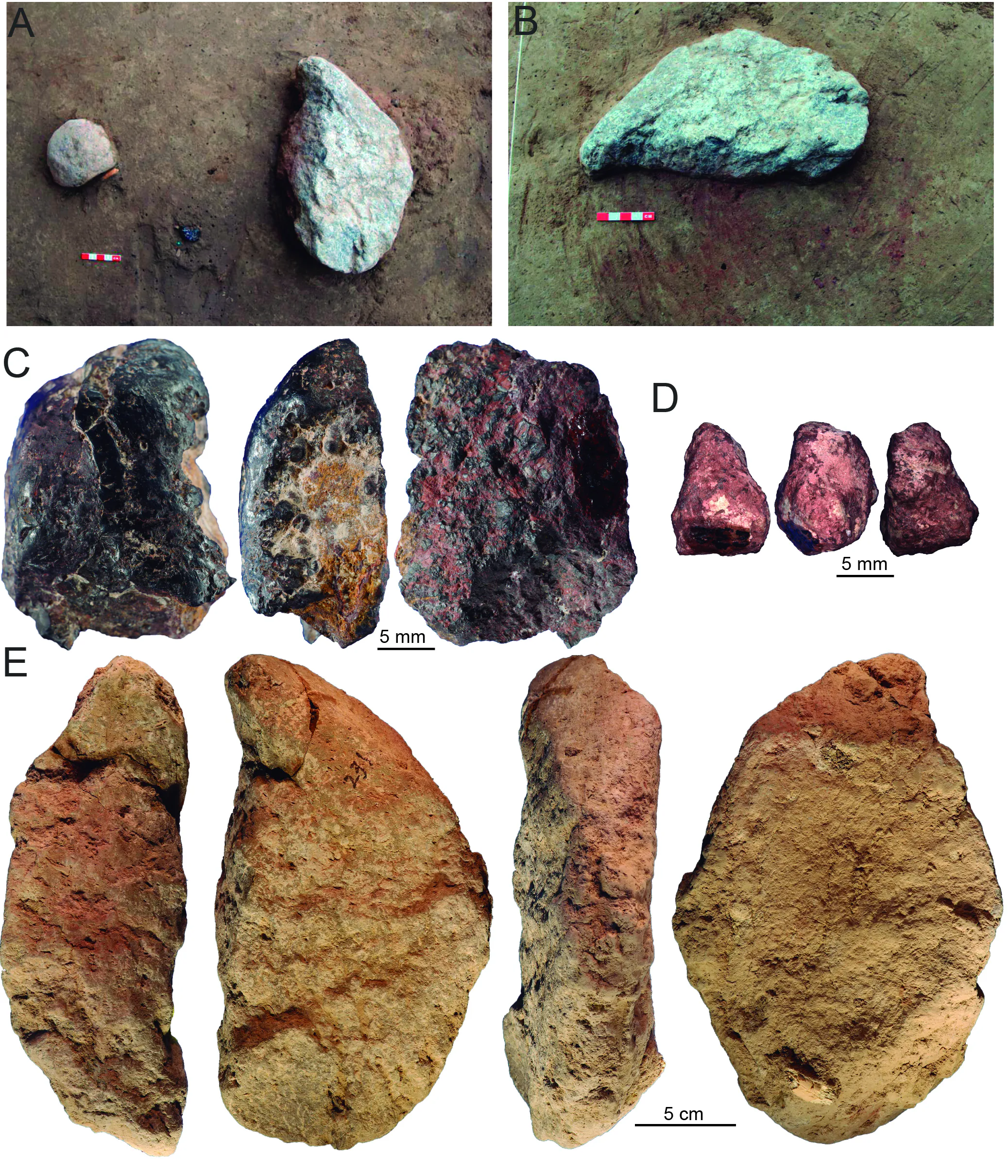 Pièces d'ocre et équipement de traitement de la pierre posés sur une tache de pigment teintée de rouge.