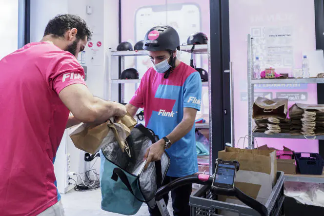 L'intérieur d'un magasin Flink à Paris, 2021. Le panier est rempli immédiatement après avoir passé une commande. Le préposé à la commande récupère les produits en rayon en suivant la commande sur son terminal Zebra et en scannant les produits un par un. L'opérateur va très vite pour mettre les produits dans son chariot et les apporter au livreur, tout devrait se passer en moins de 10 minutes. Hervé Lecke / Hans Lucas pour