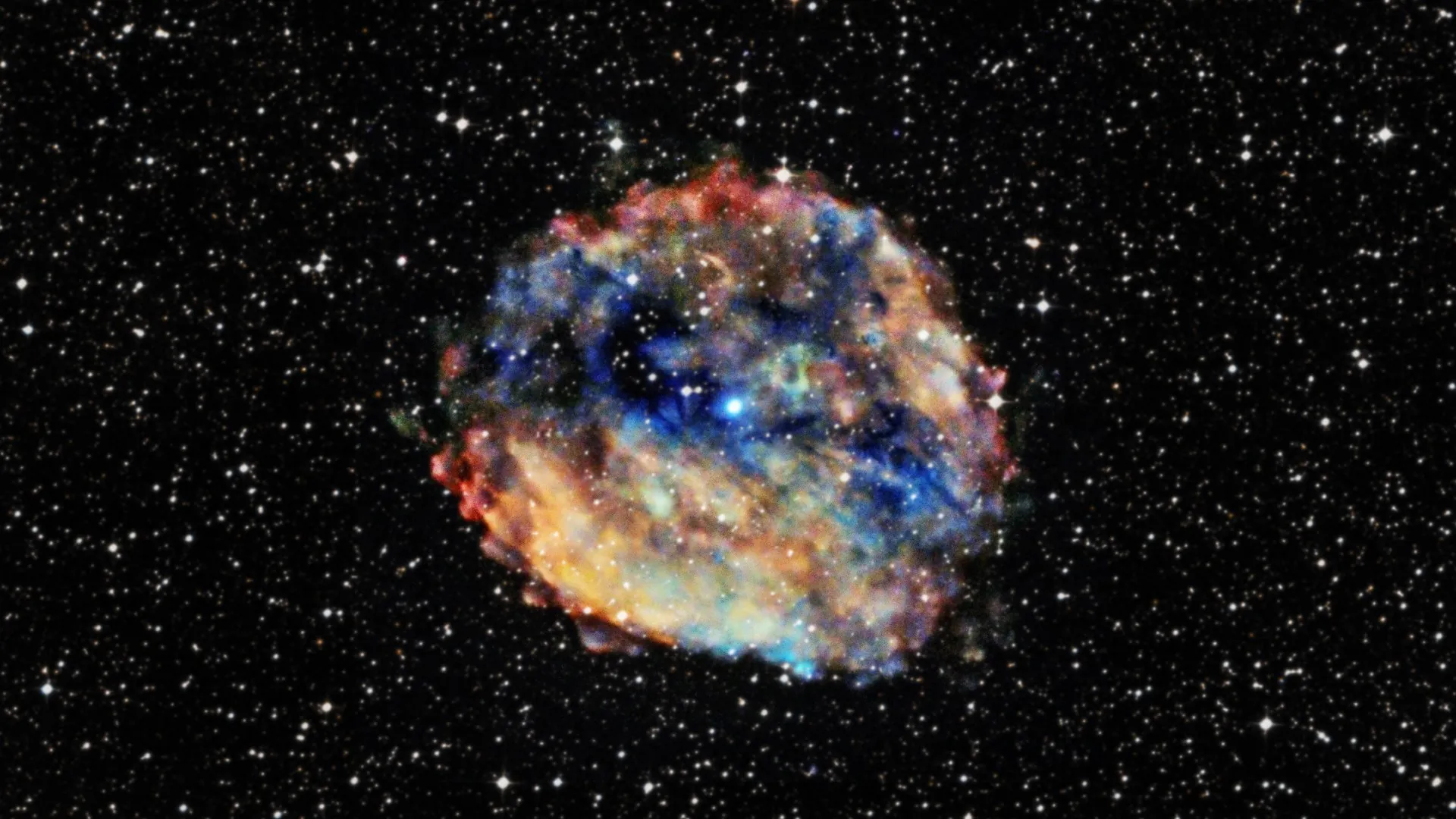 Cette image montre un pulsar, officiellement connu sous le nom de 1E 161348-5055.  Cela ressemble à une brume circulaire de brume bleue et orange sur le fond étoilé noir.