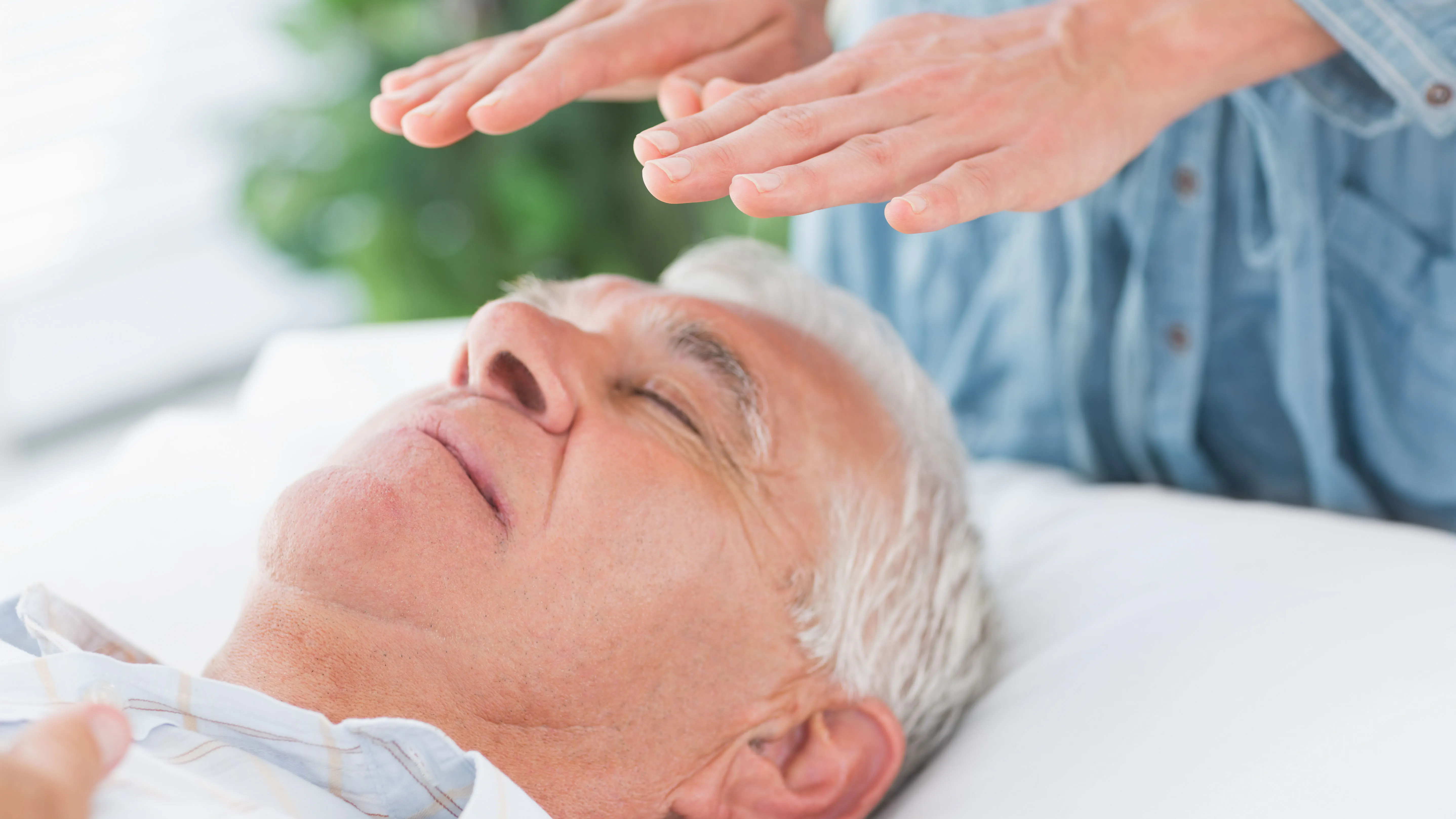 Personne exécutant le reiki sur un homme âgé