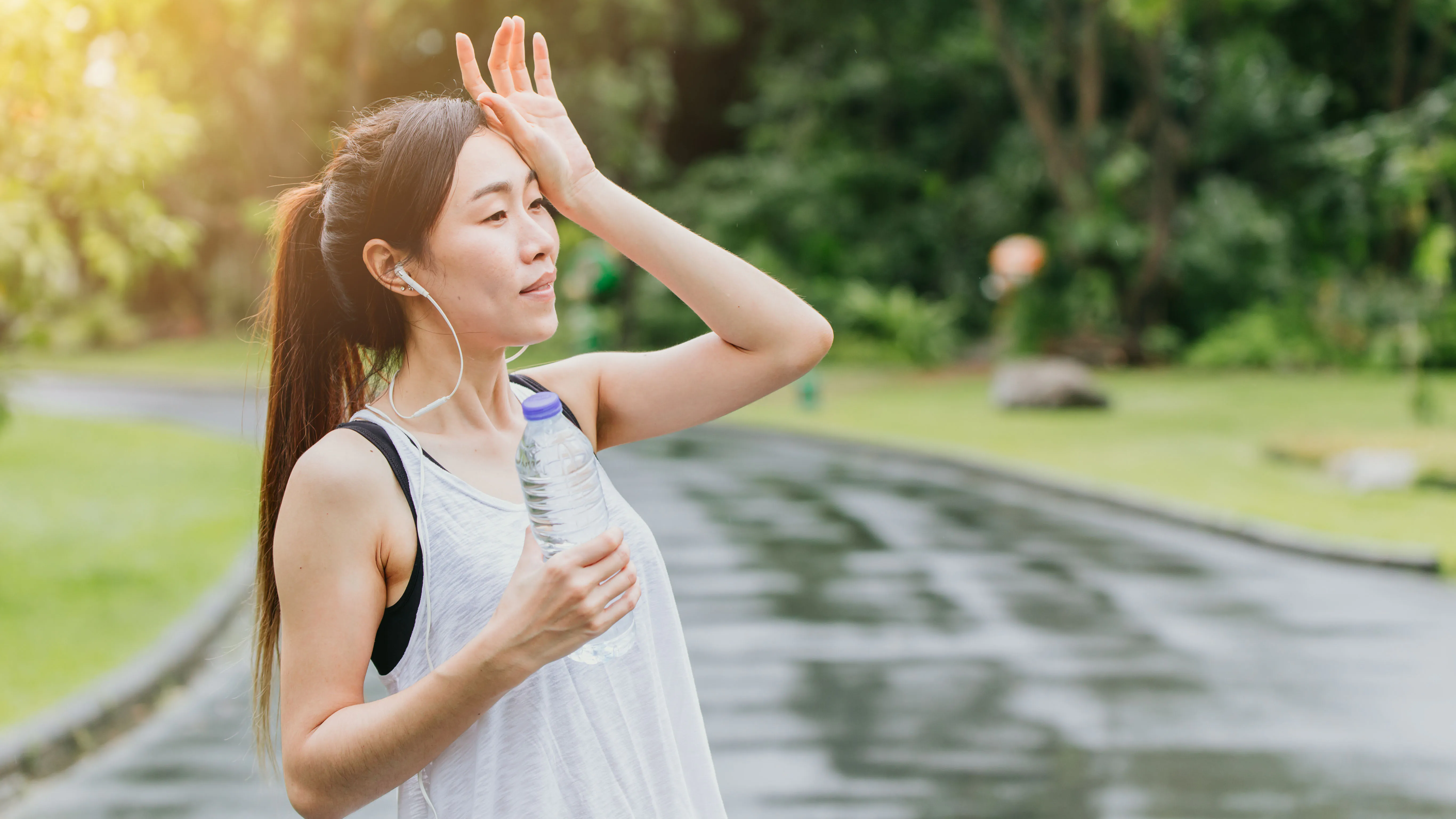 Femme faisant une pause sur la course pour boire de l'eau