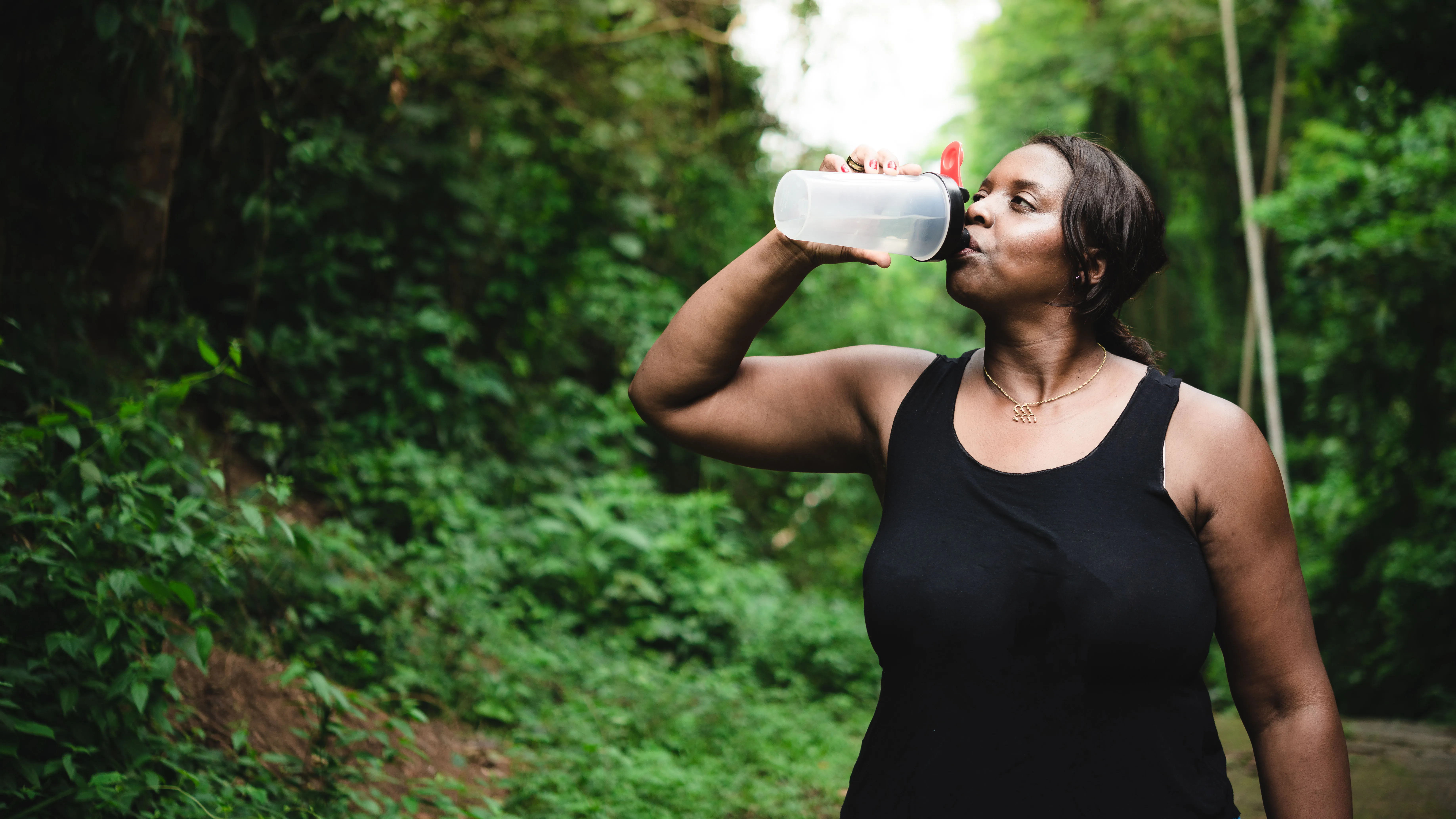 Femme buvant à la bouteille pendant l'exercice