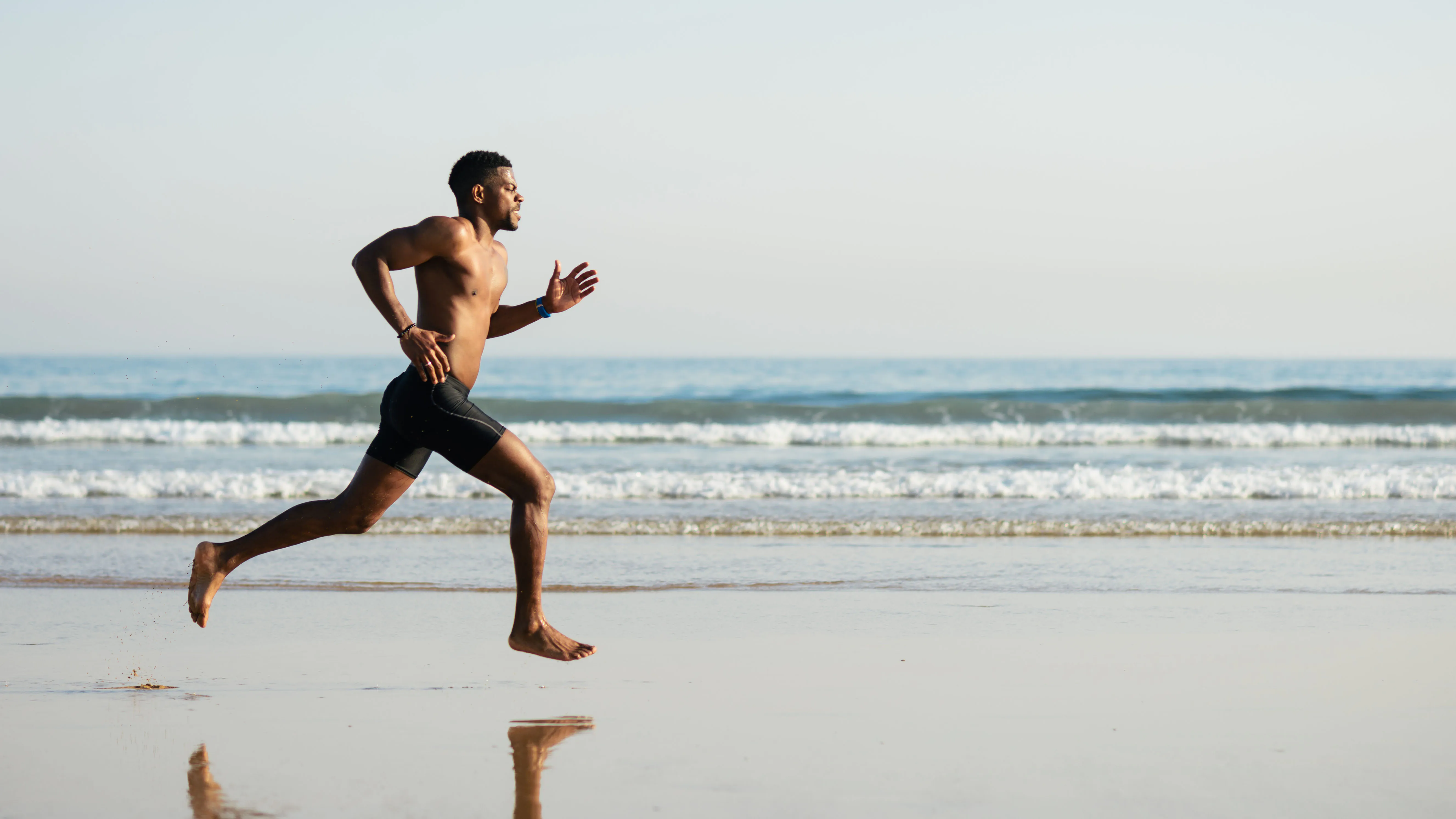 Homme qui court pieds nus sur la plage