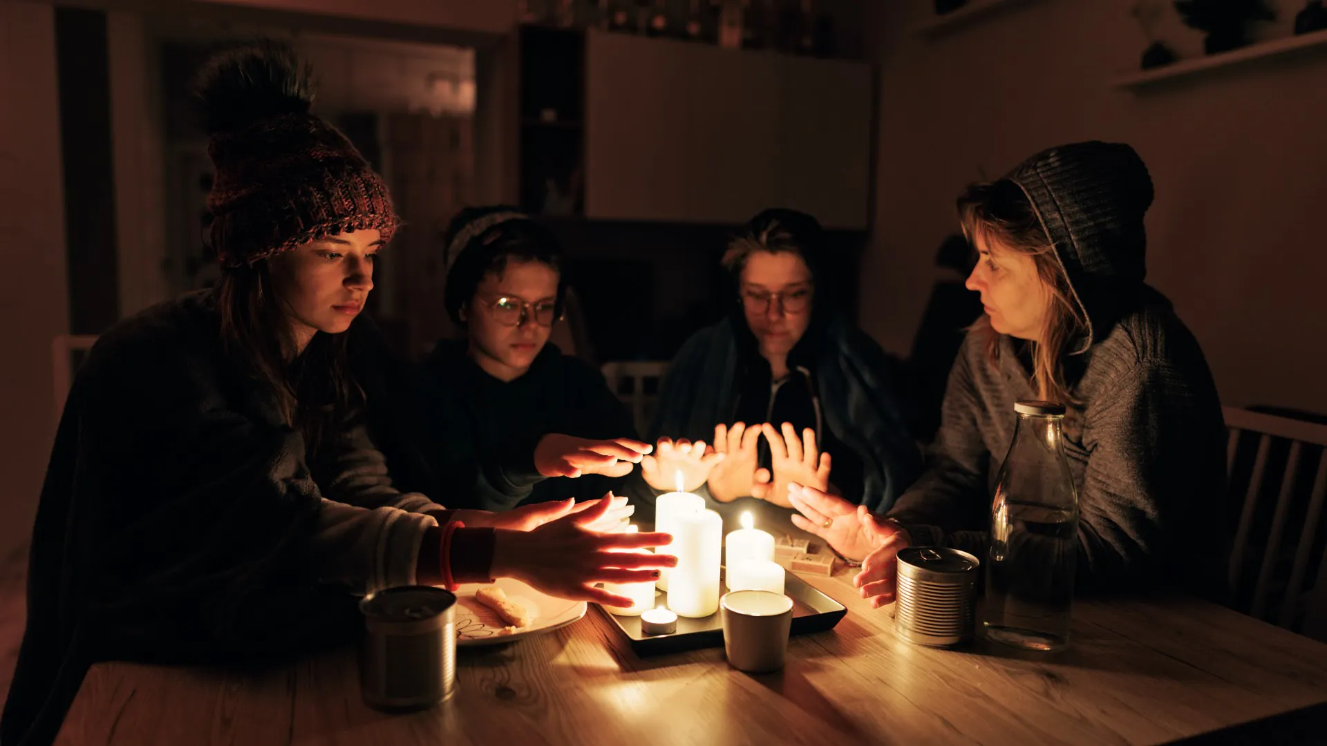 Famille assise près des bougies pendant la panne d'électricité.