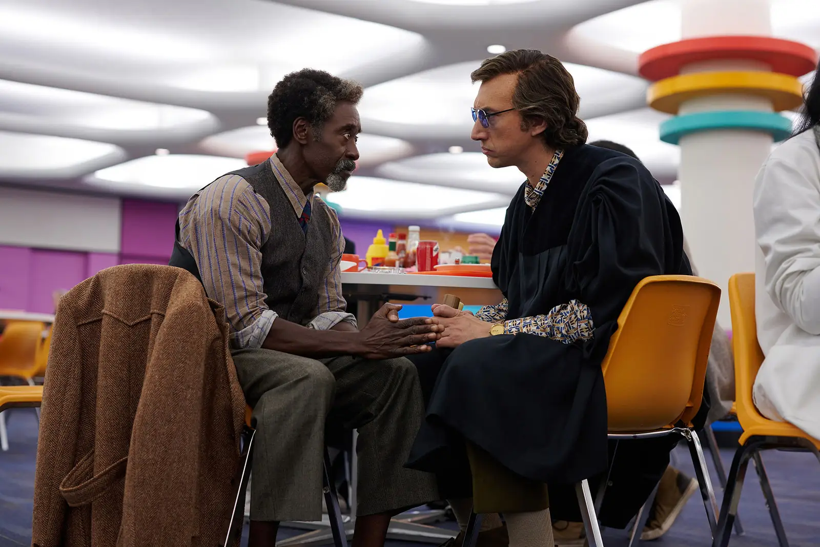 L'image peut contenir une personne assise, des vêtements, des vêtements, des meubles, une chaise et Don Cheadle