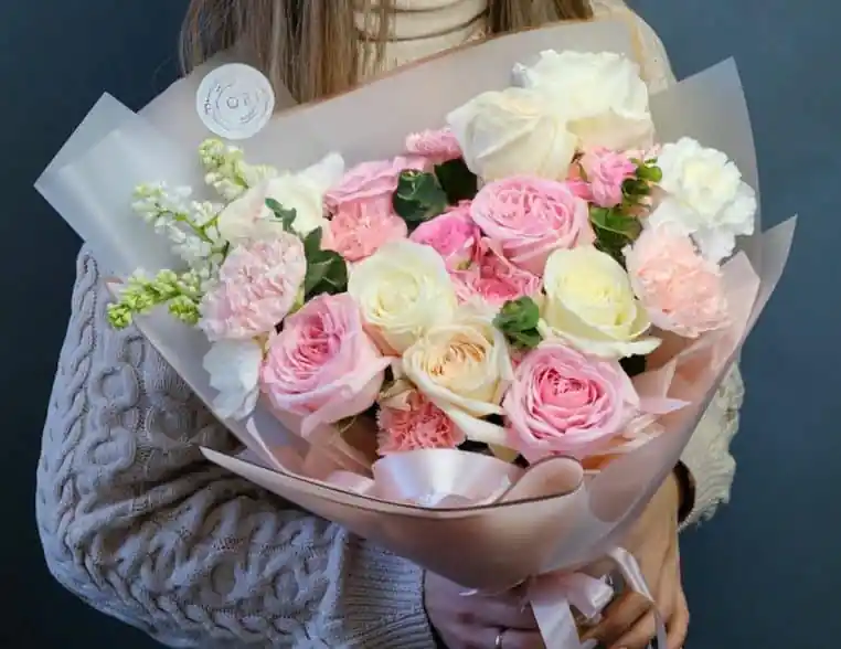 Un homme s'approche d'une jeune femme qui sort du magasin de fleurs