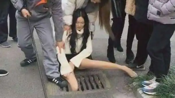 Absorbée par son téléphone au milieu de la rue, elle a passé sa jambe dans la grille d'un égout (VIDEO)