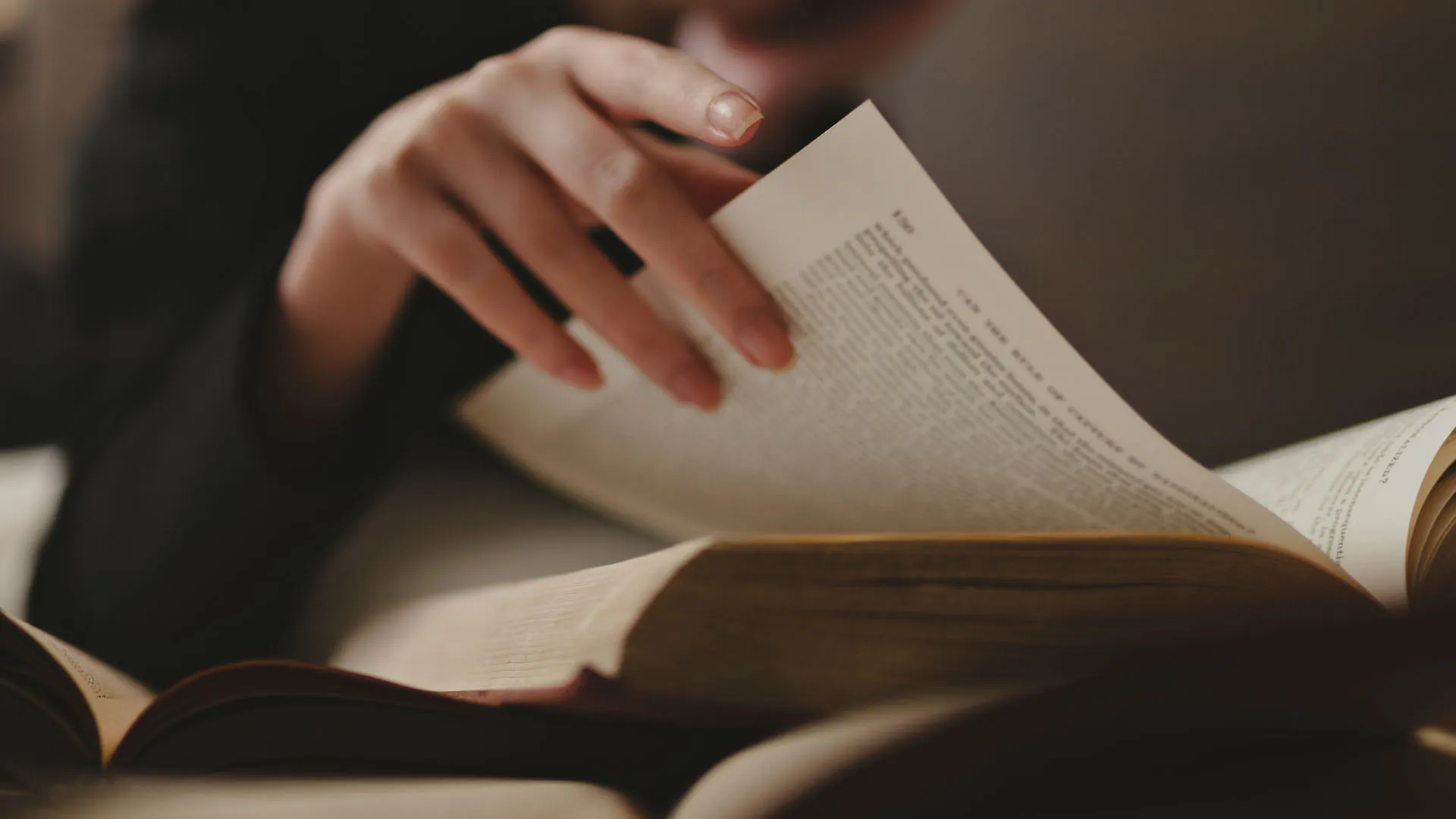 main d'une personne lisant un livre