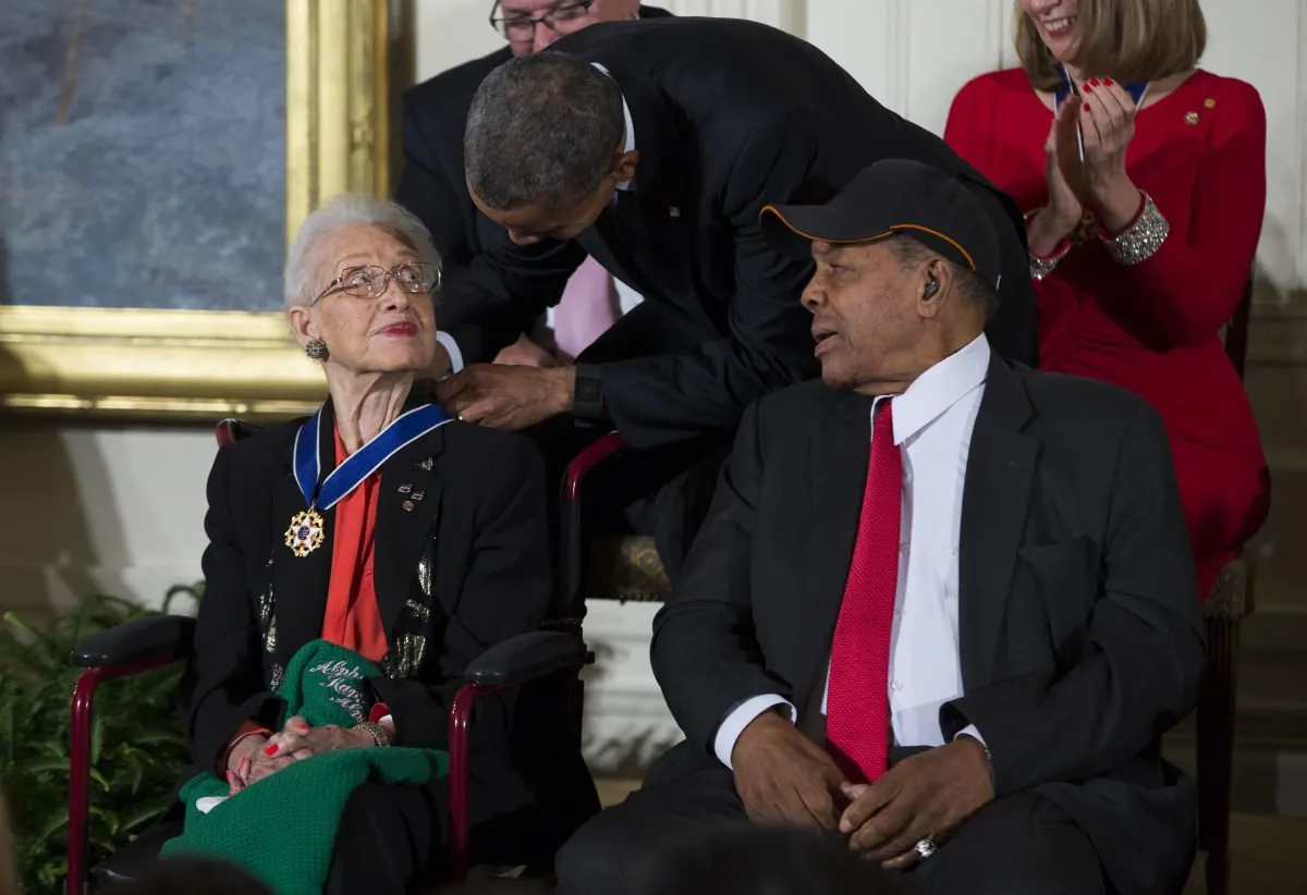 Willie Mays, à droite, regarde le président Barack Obama remettre la Médaille présidentielle de la liberté à la mathématicienne de la NASA Katherine Johnson lors d'une cérémonie dans la salle Est de la Maison Blanche, le mardi 24 novembre 2015, à Washington.  Obama reconnaît 17 personnes avec la plus haute distinction civile du pays, dont l'un des plus grands receveurs de l'histoire du baseball et un 