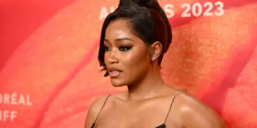 Keke Palmer apparaît sur le tapis rouge dans une robe noire.  Elle porte ses cheveux dans une touche française chic.