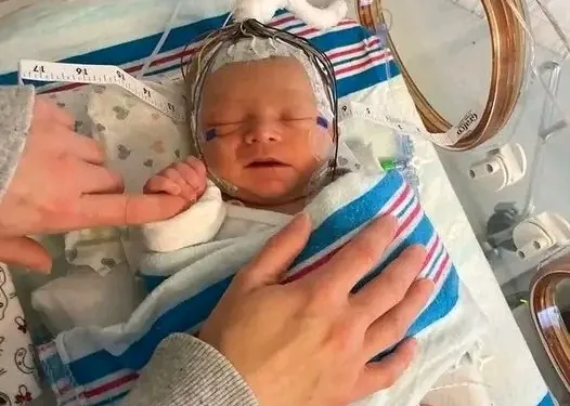 A soft image of a baby’s hand gripping a parent’s finger, or a candle lit in prayer.